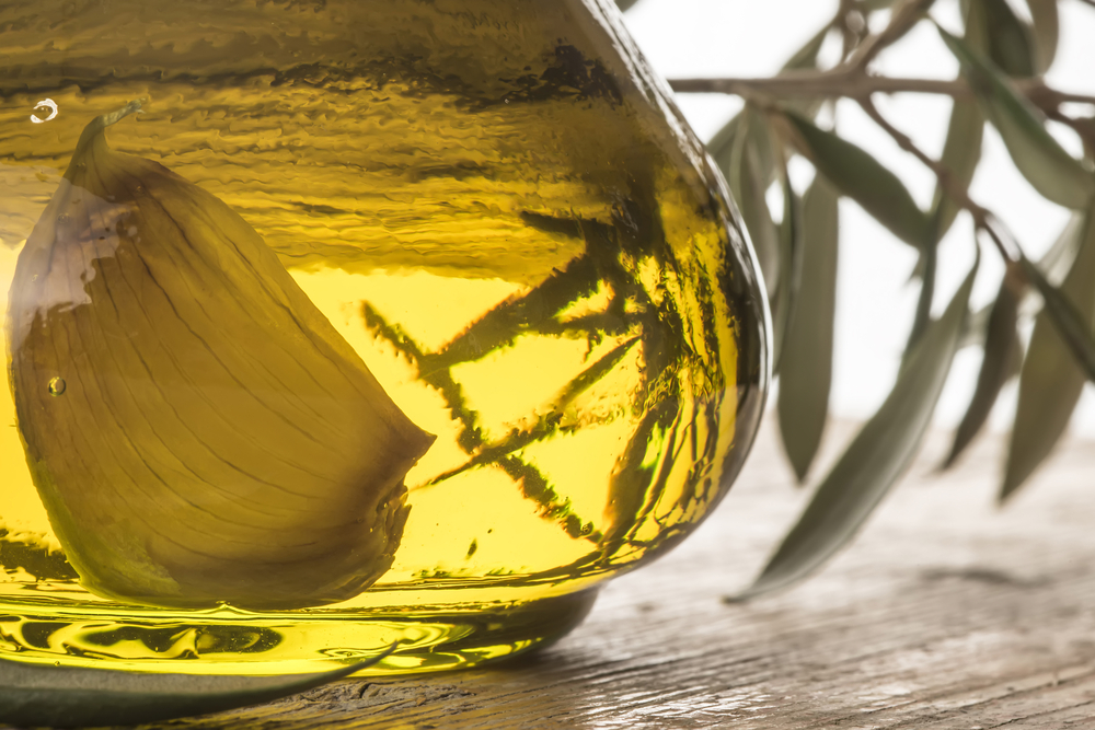 Garlic infused olive oil in a glass bottle, closeup photo