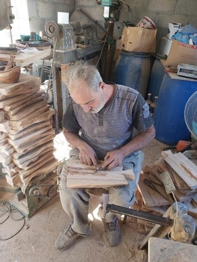 Qiesieh family members sit in their workshop, meticulously preparing their first order of olive wood cutting boards for My Olive Tree.