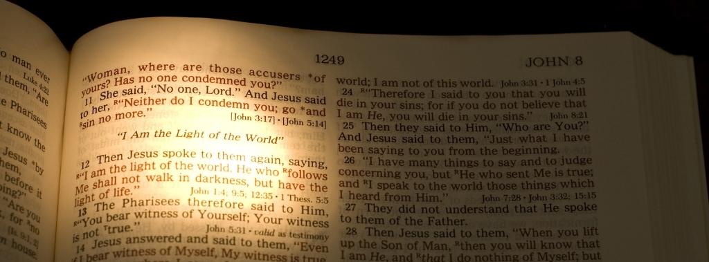 Open Bible with light shining on the John 8:12 verse I am the light of the world.